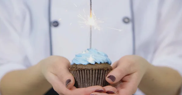Confectioner girl holding birthday cakes with burning candles