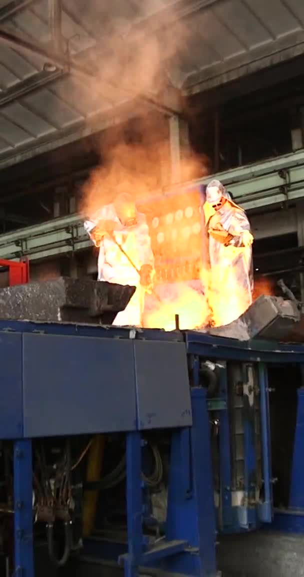 Vertikální video pro telefony a tablety. Tavení oranžového kovu v hutním závodě. Kapalné železo z naběračky — Stock video