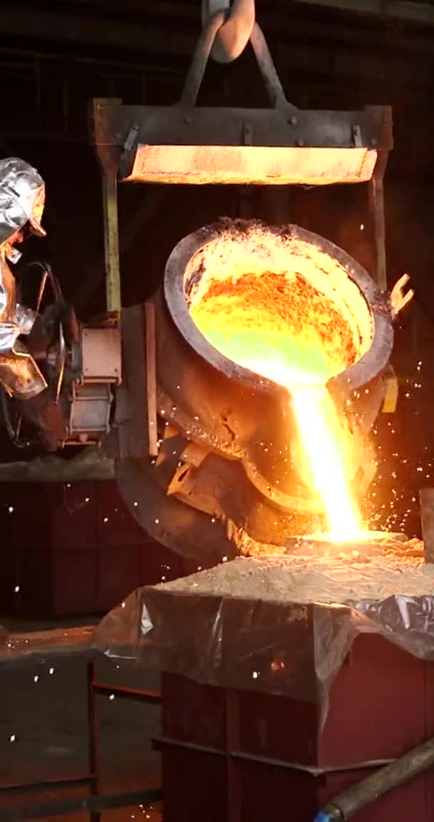 Вертикальне відео для телефонів і планшетів. Танення помаранчевого металу на металургійному заводі. Рідке залізо з ковшів — стокове відео