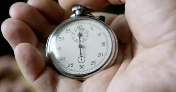 Una persona poniendo en marcha un cronómetro en negro — Vídeos de Stock