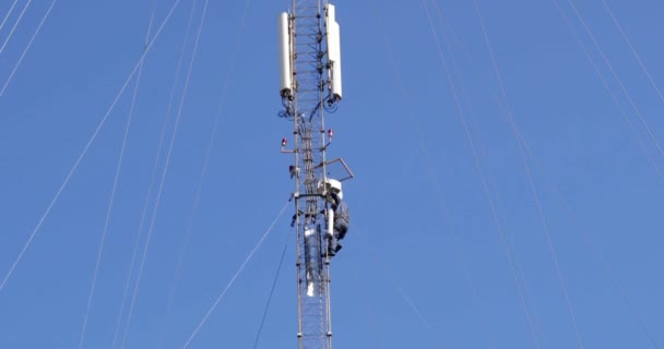 Primer plano aéreo alrededor de la torre de telecomunicaciones en un lugar rural. Las antenas de torre de telecomunicaciones y satélite transmiten las señales de 5g 4g celulares señales móviles a los consumidores y teléfonos inteligentes. — Vídeos de Stock