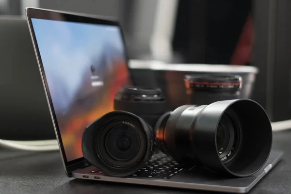 Dijital kamera, lens ve laptop. Fotoğrafçı çalışma istasyonu konsepti. Evde çalışıyorum..