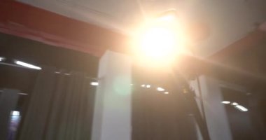 Genç yakışıklı profesyonel fotoğrafçı stüdyoda bir modelin fotoğrafını çekiyor. Ele geçirilen resimlerden memnun. Dijital kamera DSLR.