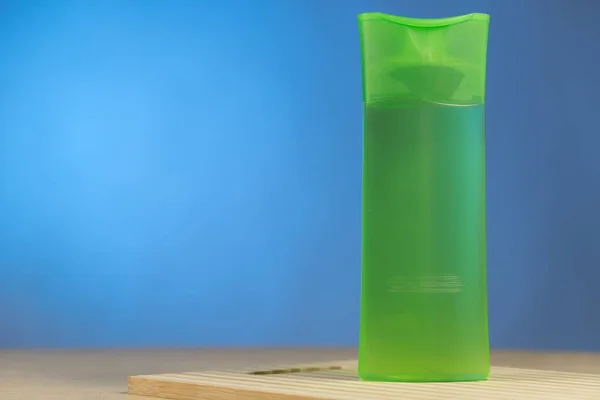 Tubo Plástico Verde Com Shampoo Isolado Fundo Azul Uma Placa — Fotografia de Stock