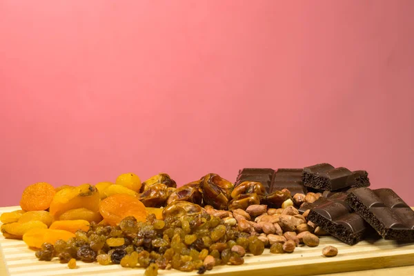Eastern sweets, dried fruits, raisins, dates, dried apricots, peanuts. On a red background