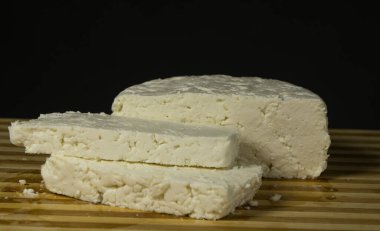 İnek sütünden yapılmış İtalyan yumuşak peyniri, siyah bir arka planda.