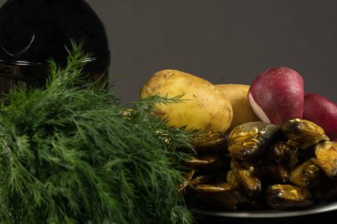 Genç patates ve füme balık, taze soğan ve dereotu, bir şişe koyu bira.