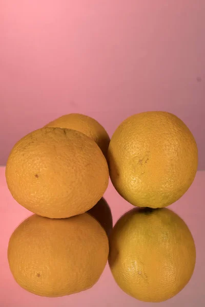橘子的宏观图像 在有粉色背景的镜子上反射出来 — 图库照片