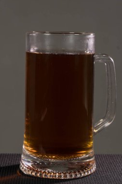 Kopyalama alanı olan tahta arka planda cam bira. Karanlık bir arka planda.