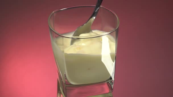 한잔을 마시면서 움직이 요구르트를 숟가락으로 저으십시오 바탕에 우유를 시킨다 — 비디오