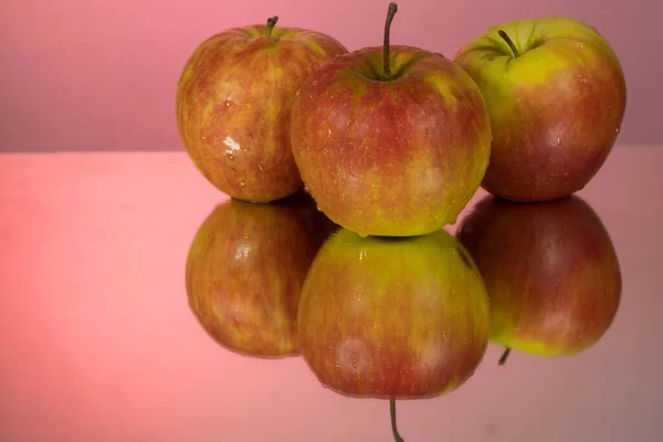 Три Красных Яблока Зеркальном Столе Красном Фоне Отражением Изолированным Вблизи — стоковое фото