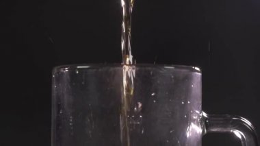 Barmen bardağa köpüklü bira dolduruyor. Karanlık bir arka planda