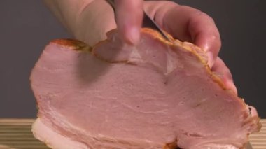 Keskin bıçakla domuz pastırması doğrayan tanınmamış bir erkek aşçıya yakın çekim.