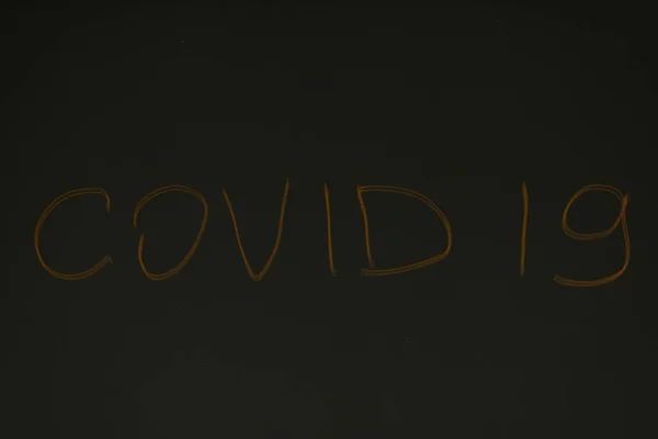 鏡面に刻まれた碑文暗い鏡の背景にCovid — ストック写真