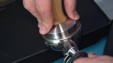 Espresso makinesinden sütlü kahve fincanına taze kahve ekliyorum.