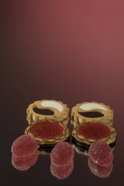 Kırmızı ayna arka planında birkaç marmelat şekeri izole edilmiş.