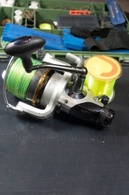 Eski ahşap bir masada balık tutma ekipmanları. Spor ve eğlence konsepti. Karanlık bir arka planda