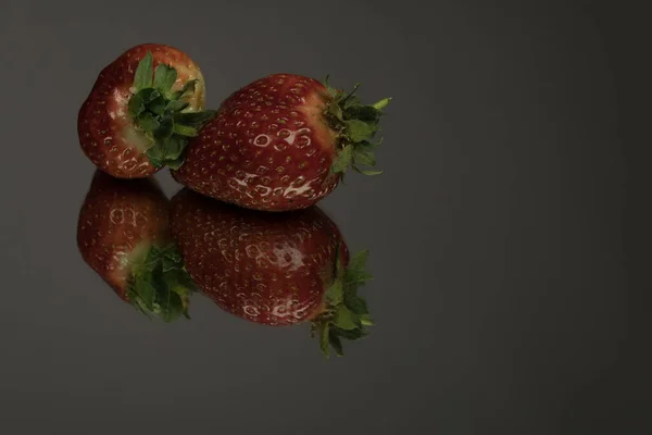 Zwei Erdbeeren Auf Spiegelschwarzem Hintergrund Eine Schmackhafte Rote Reife Erdbeere — Stockfoto