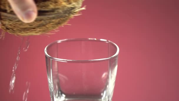 Kokossaft Wird Ein Glas Gegossen Auf Einem Roten Spiegel Hintergrund — Stockvideo