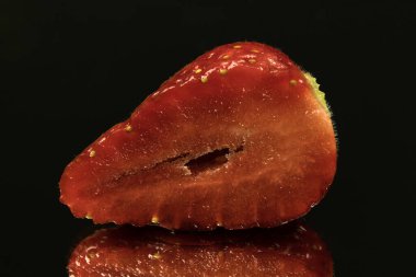 Siyah zemin üzerinde izole edilmiş taze kırmızı çilek meyveleri, yakın çekim.