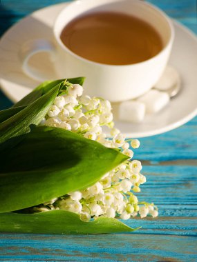 Çiçek bir buket ile beyaz bir fincan sıcak çay 