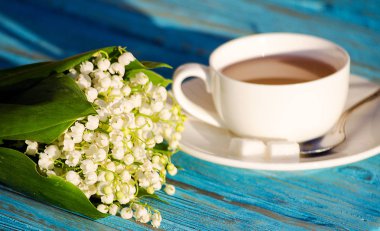 Çiçek bir buket ile beyaz bir fincan sıcak çay 