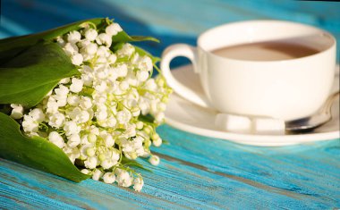 Çiçek bir buket ile beyaz bir fincan sıcak çay 