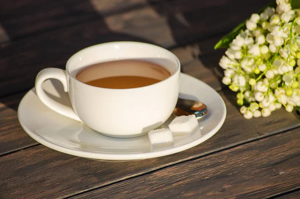 Çiçek bir buket ile beyaz bir fincan sıcak çay 