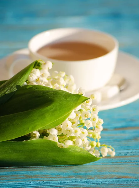 Çiçek bir buket ile beyaz bir fincan sıcak çay 