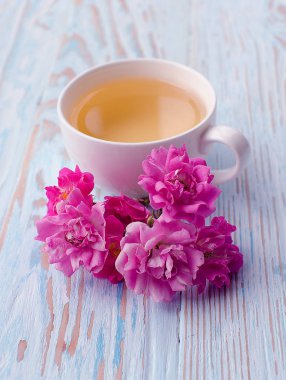Güzel kokulu sıcak çay gül ahşap arka plan üzerinde