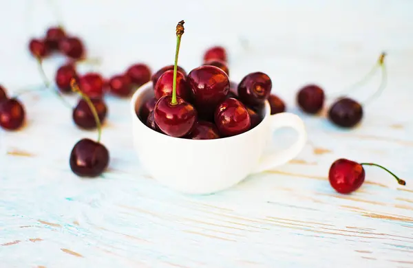 Red ripe cherry on a background of trees — Stock Photo, Image