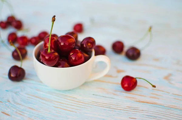 Red ripe cherry on a background of trees — Stock Photo, Image