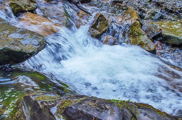 Un ruscello in montagna scorre lungo le rocce e una tempesta — Foto Stock
