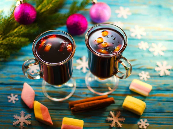 A hot drink of mulled wine and spices on a wooden background — Stock Photo, Image