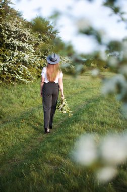 Baharda açık havada yürüyen uzun saçlı mutlu kız.