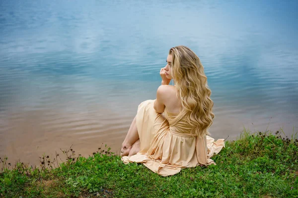 Belle Fille Triste Assise Sur Le Bord Du Lac Dans Une Robe Le Concept De Solitude Douleur Depression Stock Photo