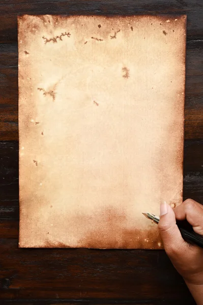 Старая бумага и ручка под рукой — стоковое фото