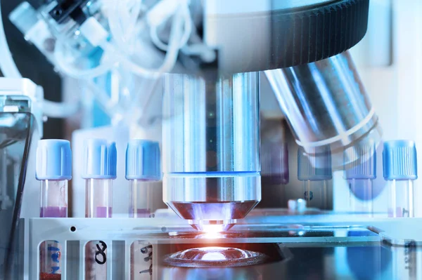 Close up shot of microscope at the blood laboratory and detail shot of steralized surgery instruments with a hand grabbing a tool — Stock Photo, Image