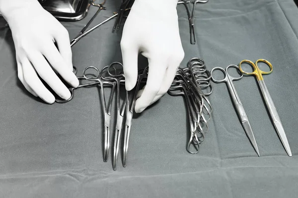 Detalhe tiro de instrumentos de cirurgia esterilizados com uma mão agarrando uma ferramenta — Fotografia de Stock