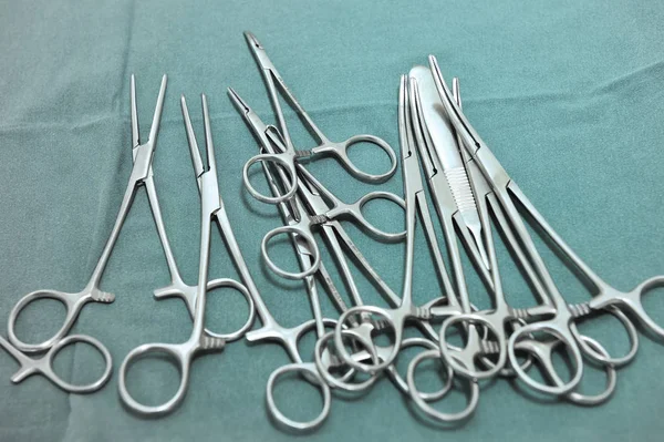 Dettaglio scatto di strumenti chirurgici sterizzati con una mano che afferra uno strumento — Foto Stock