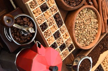 Taze çekilmiş kahve çekirdekleri bir metal filtre ve kahve çekirdekleri ile kırmızı çaydanlık 