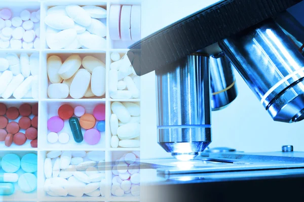 Close up shot of microscope at the blood laboratory and drugs pills — Stock Photo, Image