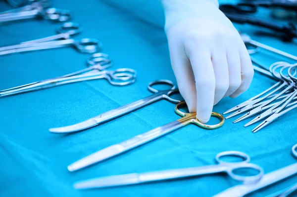 Detail shot of steralized surgery instruments with a hand grabbing a tool — Stock Photo, Image