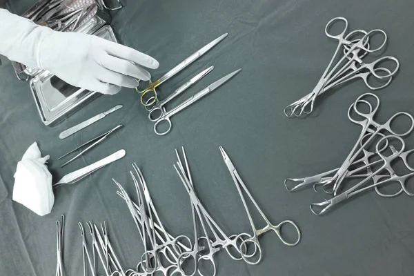 Detail shot of steralized surgery instruments with a hand grabbing a tool — Stock Photo, Image