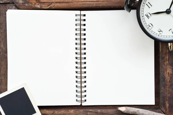 Lege notebook, fotolijstjes, potlood en klok — Stockfoto