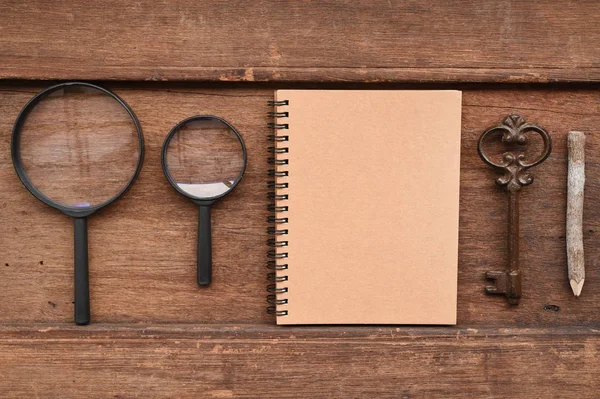 Puste notebook ołówek, klucz i szkło powiększające — Zdjęcie stockowe