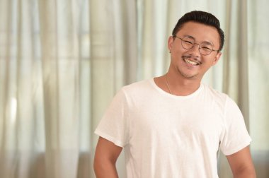 Kameraya bakarak gülmek gülümseyen genç adam portresi