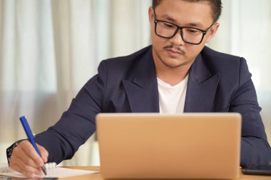 Ofisteki masasında oturan genç adamın portresi.