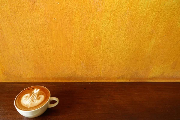 木製の背景にラテアートコーヒーを飲みながら — ストック写真