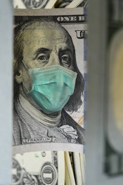 Arkaplanı yüz maskeli 100 dolarlık banknotu kapat